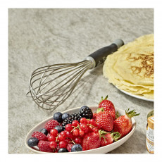 Eine Frauenhand mit einem Schneebesen über eine Schüssel Schlagsahne und  Puderzucker neben einem Handtuch und Schüsseln mit Puderzucker und Ricotta.  Flach liegend Stockfotografie - Alamy